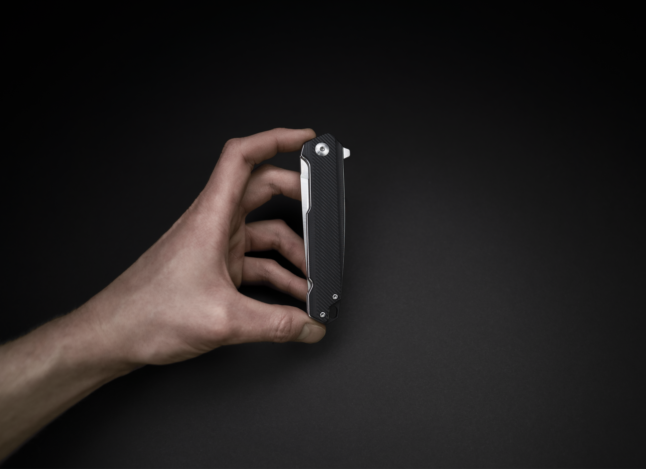 The Bellum by Korcraft Black pocket knife closed held in the hand