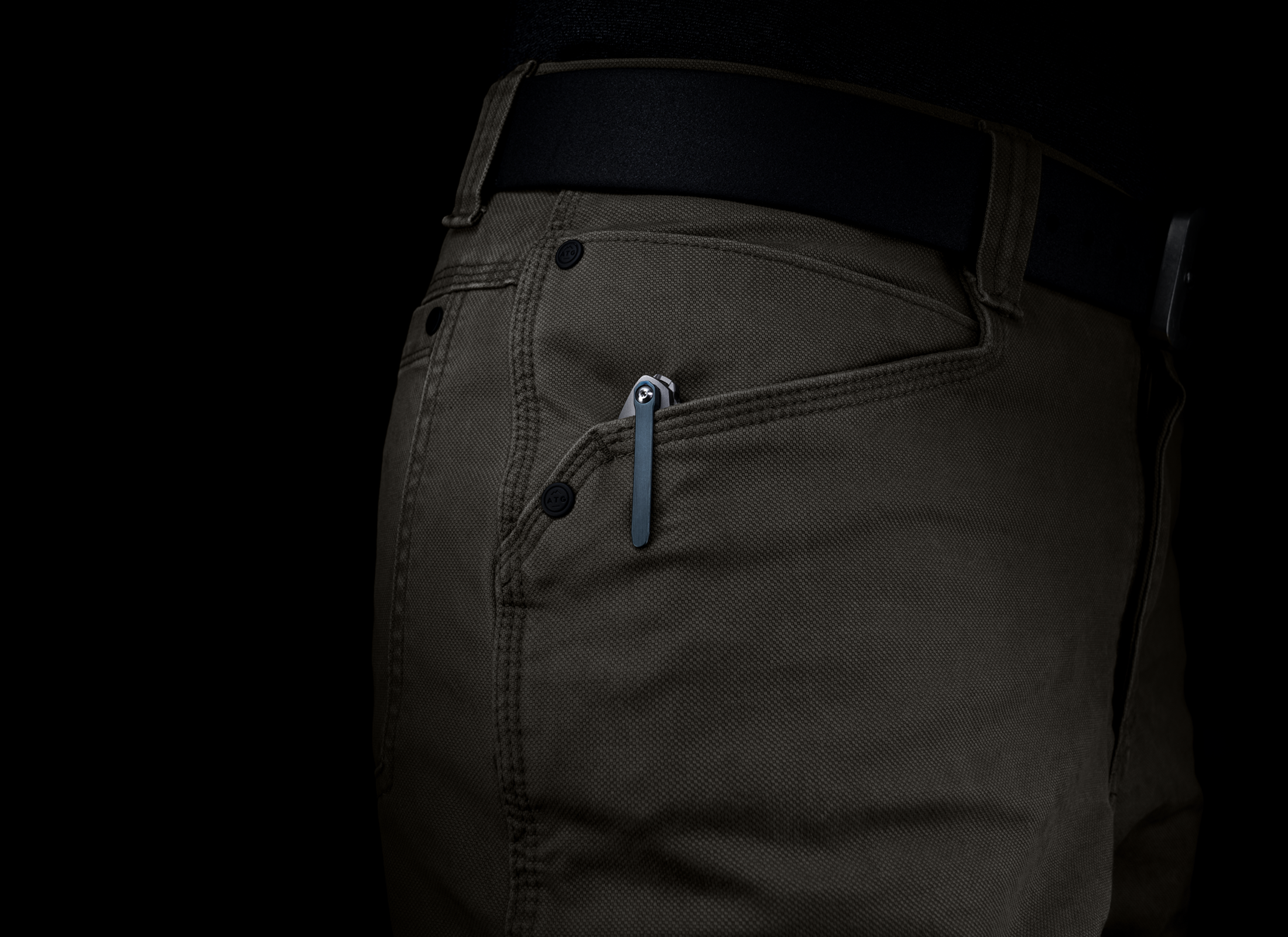 The Alta by Korcraft, titanium handle and m390 blade closed in pocket on black background